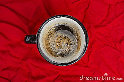 Cup of coffee on crumpled red cloth top view close-up Stock Photo
