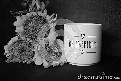 Cup of coffee and flowers. With inspirational note - Be inspired in black and white background Stock Photo