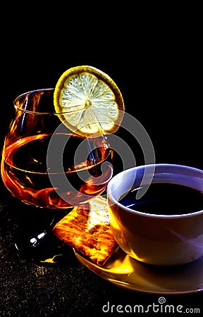 Cup with coffee and a glass with cognac and a slice of lemon Stock Photo