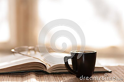 Cup of coffee glasses rest on the open book against Stock Photo