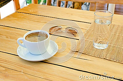 Cup of coffee, glasses, water on table Stock Photo