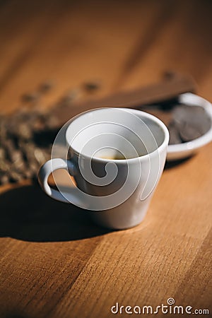 Cup of coffee with grains and chocolate on wooden table Stock Photo