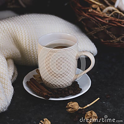 A cup of coffee is the key to a good mood. Wooden smiley on a dark, black, textural background. On the table there is a white, Stock Photo