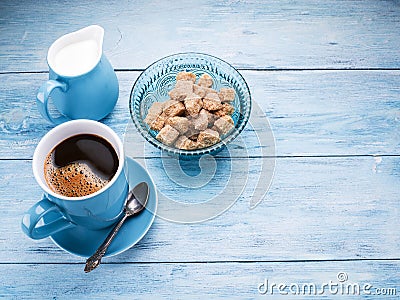 Cup of coffee, milk jug and cane sugar cubes. Stock Photo