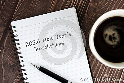 Coffee and notepad with text - 2024 New Year's Resolutions Stock Photo