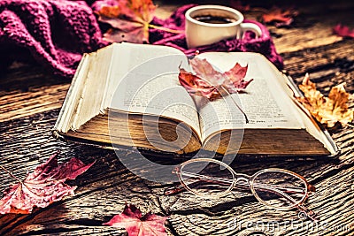 Cup of coffee old book glasses and autumn leaves. Stock Photo