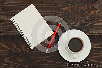 Cup of coffee, pen and notebook on wooden desktop. View from above Stock Photo