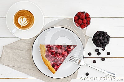 A cup of coffee and piece of homemade pie with red and black raspberries on white wooden table. Stock Photo