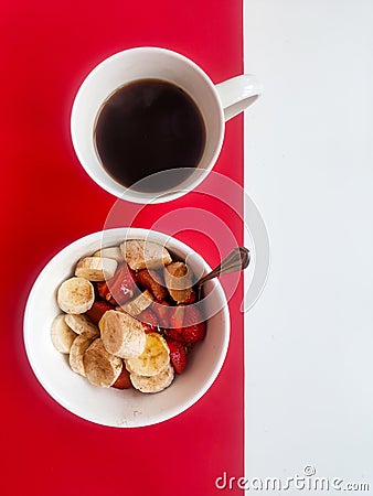 Cup of coffee and a plate of oatmeal with banana Stock Photo
