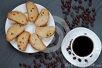 Cup of coffee, scattered coffee beans and toasted bread on a wooden background Stock Photo