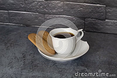 Cup of coffee on the table with biscuits cookies black bricks background Stock Photo