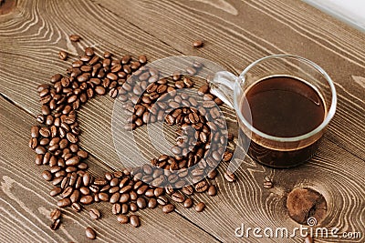 Cup of coffee on a tray and coffee beans in the shape of a heart Stock Photo