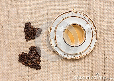 Cup of coffee and two coffee hearts on burlap background. Top view, copy space Stock Photo