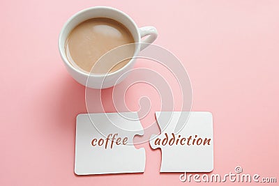 cup of coffee and two white disconnected puzzles with the inscription coffee addiction on a pink Stock Photo