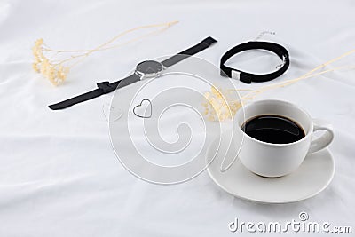 A cup of coffee with woman accessories on white bed Stock Photo