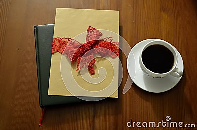 Cup of coffee on wooden table. Books and pile of letters in the background Stock Photo