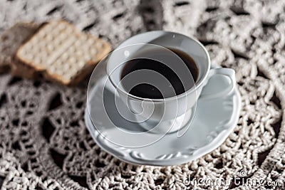 Cup of coffee on a table lined with crochet. Stock Photo