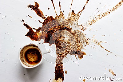 A Cup of custard coffee spilled on a white table background, top view of a Beautiful spot of coffee brewing. Fortune Stock Photo