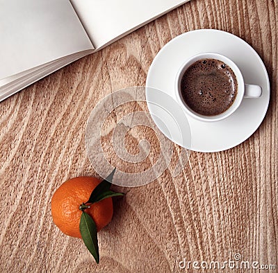 Cup of dark coffee, mandarin, opened book Stock Photo