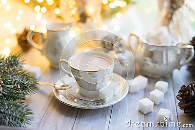 A cup of English tea with milk from an old mother-of-pearl porcelain service with refined sugar. Christmas tea party breakfast on Stock Photo