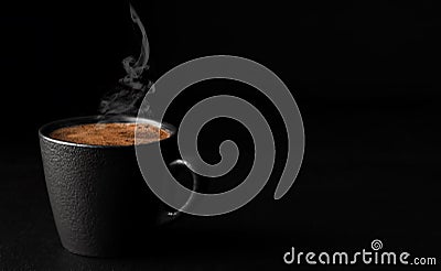 A cup of espresso with foam, steam rises above a cup of coffee. Black stone background. Copy space for text. Close-up, shallow Stock Photo