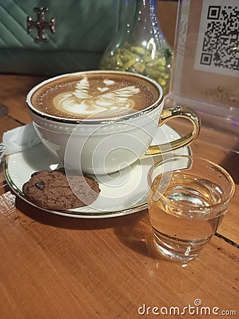 a cup of espresso latte with a piece of chocolate cookies Stock Photo