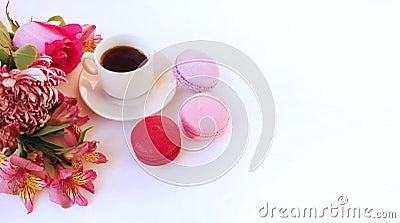 A cup of espresso, red and pink macaroons and a bouquet of alstroemeria on a white background. Festive breakfast. Stock Photo