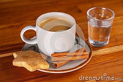 a cup of espresso, a small glass of sparkling water and cookies Stock Photo