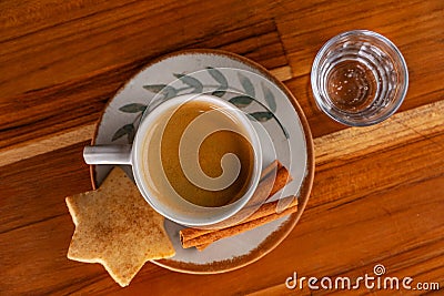 a cup of espresso, a small glass of sparkling water and cookies Stock Photo