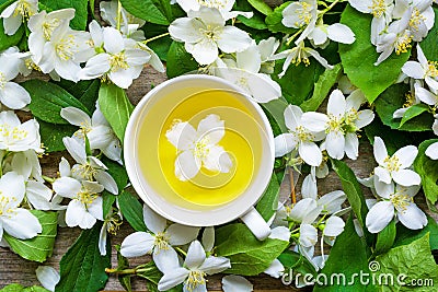 Cup of green herbal tea with jasmine flowers over nature jasmine background Stock Photo