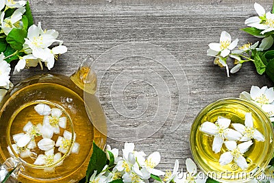 Cup of green herbal tea with jasmine flowers and teapot Stock Photo