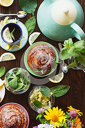 Cup of herbal tea with lemon and mint leaves, ginger root and baked goods Stock Photo