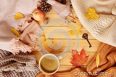 Cup of hot aromatic coffee, autumn leaves, apple, cozy scarves and knitted sweaters, flat, concept of hugg, winter or autumn mood Stock Photo