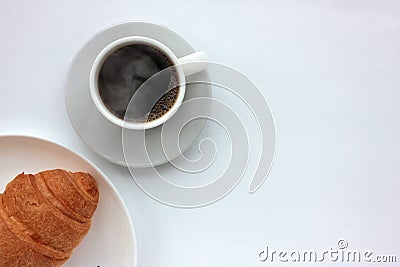 Cup of hot blak coffee with steam and croissant on white background. Top view, copy space. Morning espresso on table. Stock Photo