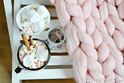 Cup with hot chocolate, bowl with marshmallows, jar with chocolate, pink pastel giant plaid Stock Photo