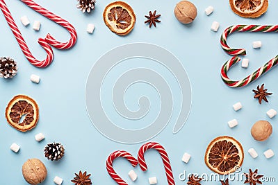 Cup of hot chocolate with marshmallow cocoa powder and caramel nuts, oranges on pastel blue background with copy space. Christmas Stock Photo