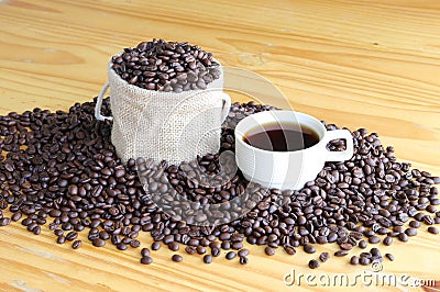 A cup of hot coffee with roasted coffee beans on the wooden table Stock Photo