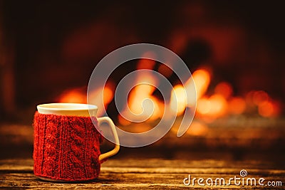 Cup of hot drink in front of warm fireplace. Holiday Christmas c Stock Photo