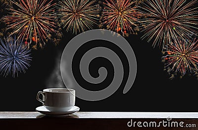 Cup of hot drinks on wooden desk with new year celebrate fireworks on night sky Stock Photo