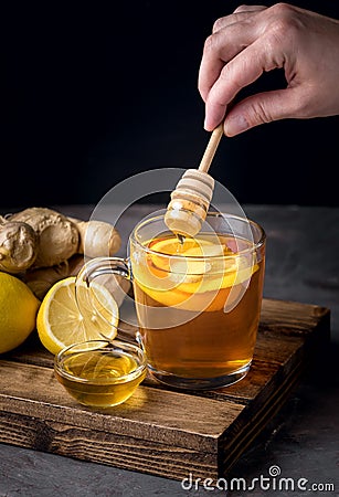 Cup of Hot Ginger Cranberries Tea with Lemon and Honey on Wooden Tray Dark Photo Female Hand Vertical Healthy Drink Stock Photo