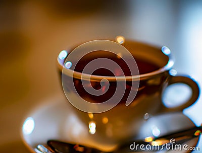 Cup of a hot tea in cafe. Anamorphic bokeh effect. Tilt-shift photo. Tasty aromatic tea in a lovely cup with a saucer Stock Photo