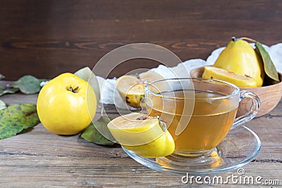 Cup of hot tea and fresh quince fruit on table Stock Photo