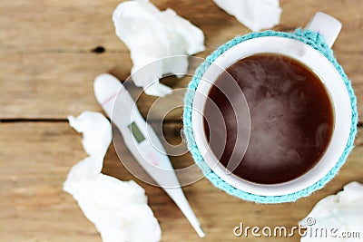 Cup of hot tea, paper wipes and thermometer on wooden table suggesting flu season Stock Photo