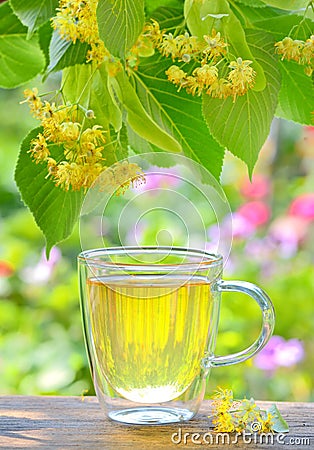 Cup with linden tea and flowers on wooden table Stock Photo