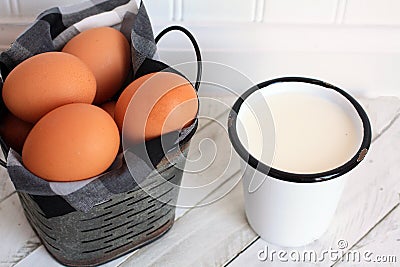 Cup of milk and brown Eggs in metal bucket Stock Photo
