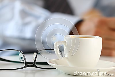 Cup of morning coffee and glasses on worktable Stock Photo