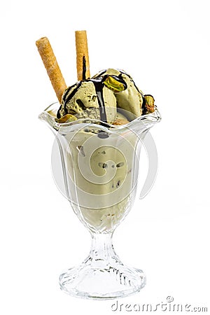 A cup of pistachio ice cream topped with chocolate sauce and cones Stock Photo