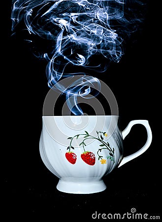 Cup with steam coming on top against a black background Stock Photo