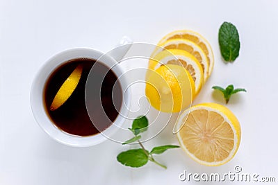 A cup of tea along with mint and lemon. Tea for colds. Natural cures for the disease. Vitamin C. Black tea with lemon on Stock Photo