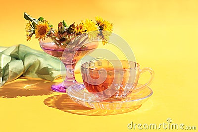 A cup of tea with a bouquet of dandelions on a yellow background, a place for text Stock Photo